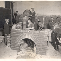 Black and white image of men practicing bricklaying