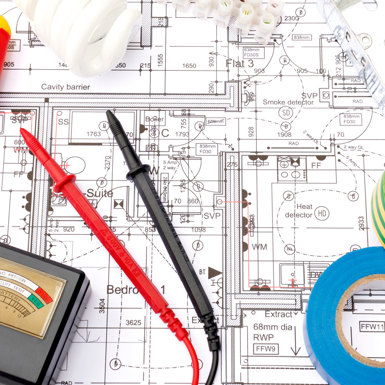 A bird's-eye view of blueprints, electrical tape and tools