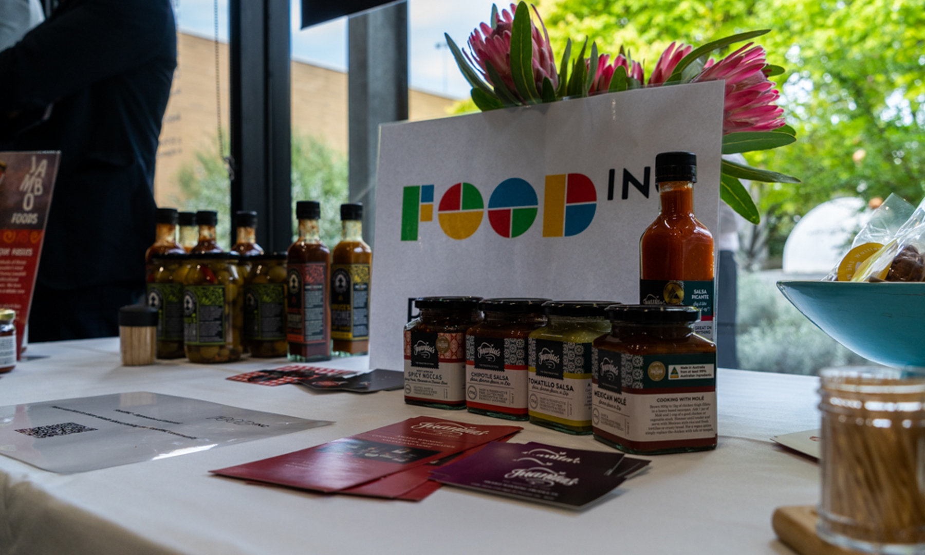 Packaged and baked food products on a table with brochures